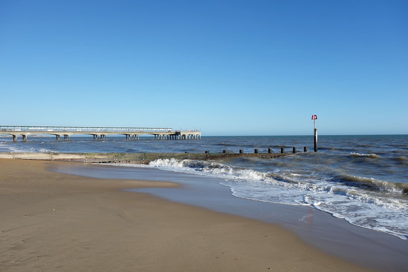 Sand and promenade at Boscombe beach, looking along the shoreline east of Bournemouth town centre