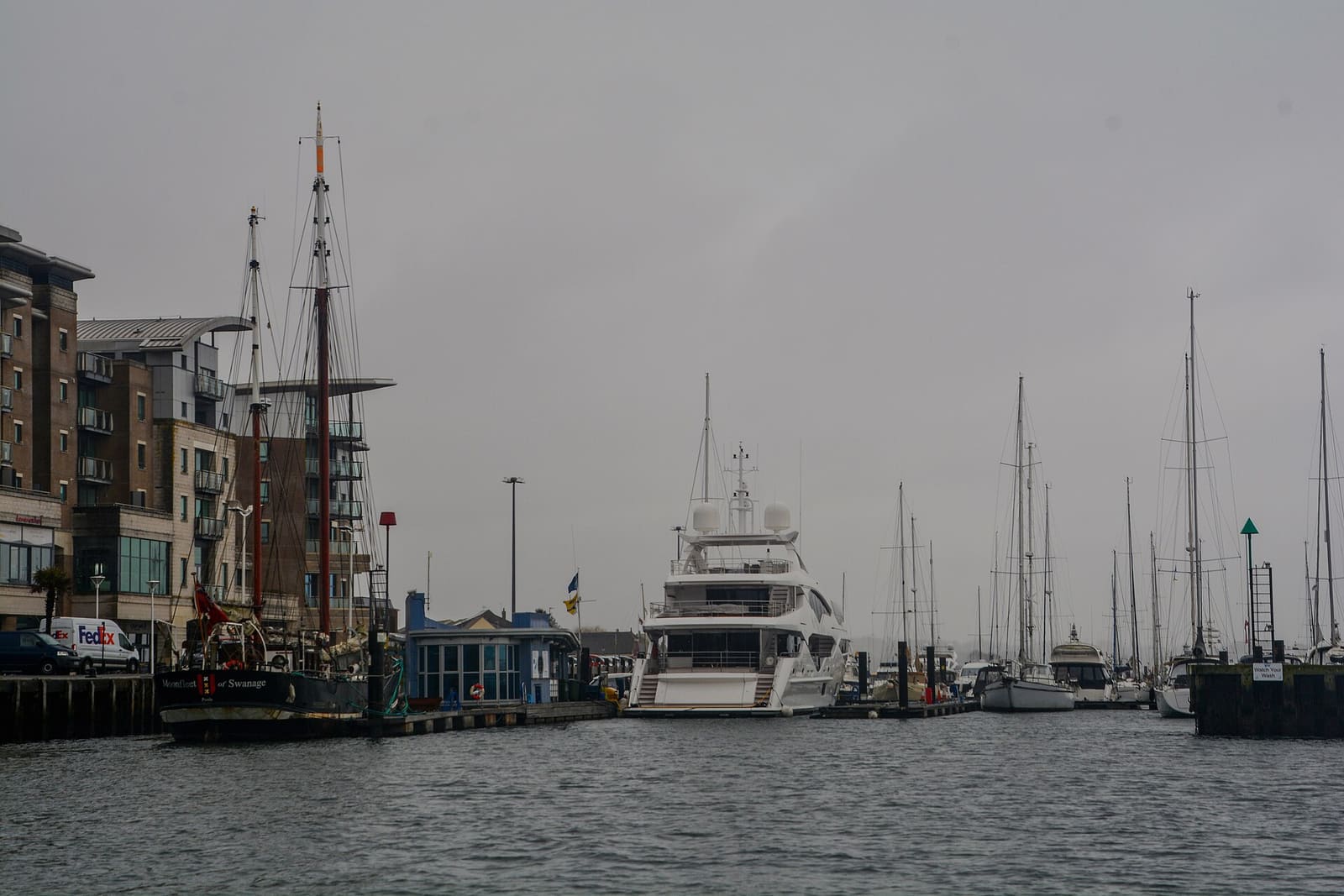 Boats moored along Poole Quay with the harbour water beyond